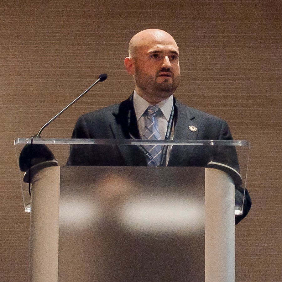 Adam Scott Wandt speaking at a podium